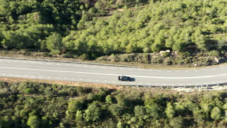 BMW-driving-beautiful-sunny-Montserrat-mountain-woodland-road-aerial-Birdseye-view