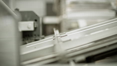 Paper-traveling-on-in-the-printing-house-on-the-production-line,-close-up-shot