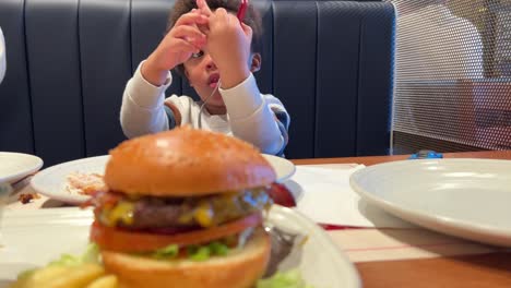 Impatient-two-year-old-black-baby,-mix-raced,-wishing-to-taste-his-burguer