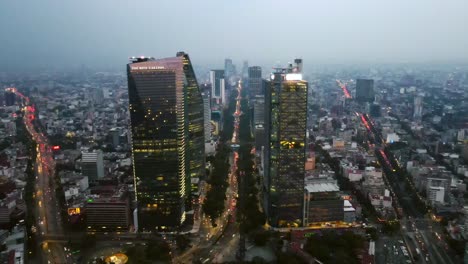 Dolly-En-Vista-Aérea-De-La-Torre-Bbva-Y-La-Torre-Mayor-En-La-Avenida-Paseo-De-La-Reforma-Por-La-Noche-Con-Luces-De-Camión-Y-Arquitectura-Iluminada,-Ciudad-De-México