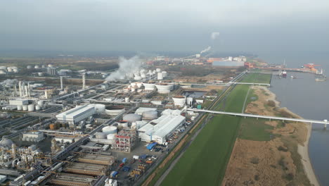 Rauch--Und-Dampfaufsteigen-Einer-Industrieanlage-An-Einem-Fluss,-Co2-emissionen,-Luftverschmutzung,-Abgase,-Luft