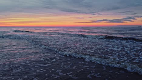 Foamy-waves-in-sea-during-colorful-sunset,-static-shot