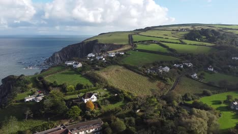 Aerial-drone-tracking-shot-of-an-English-village-in-the-countryside-with-a-rocky-coastline---Lee-Bay,-Beach,-Ilfracombe,-Devon