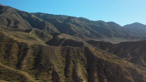 Cinematic-drone-shot-flying-over-mountain-ridges-at-Fairy-Tale-Canyon-near-Issyk-Kul-Lake-in-Karakol,-Kyrgyzstan