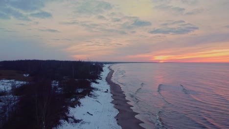 Wonderful-winter-snow-covering-vast-shoreline-in-Latvia,-Baltic-sea,-sunset