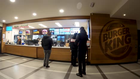 Kuriere-Warten-Auf-Essensbestellungen-Am-Bestellschalter-Im-Burger-King-Restaurant---Brüssel,-Belgien