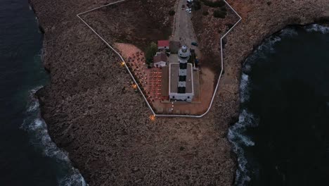 Dark-aerial-tilt-up-reveal-of-Artrutx-lighthouse-in-Menorca-Spain
