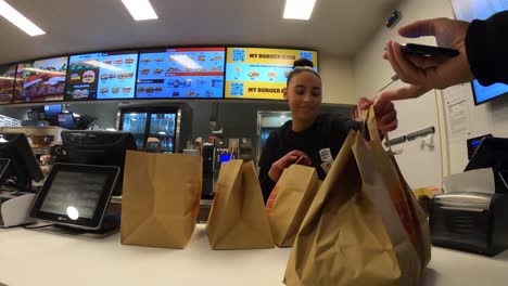 Der-Mitarbeiter-Von-Burger-King-Gibt-Dem-Lieferkurier-Eine-Tasche-Mit-Essen-Zum-Mitnehmen