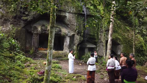 Balinesische-Priesterin-Leitet-Religiöse-Zeremonie-In-Der-Steinhöhle-Des-Tempels-Goa-Garba-Bali-Mit-Alter-Archäologischer-Architektur,-Indonesischer-Hinduistischer-Tradition