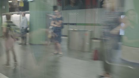 Pov-Desde-El-Interior-De-Un-Metro-Que-Llega-A-Una-Estación-De-Metro-Verde-En-Munich,-Alemania,-Mientras-La-Gente-Espera-Que-Llegue