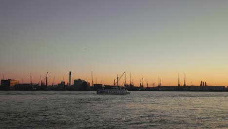 Sunset-in-the-Rotterdam-harbour,-a-ship-passing-by