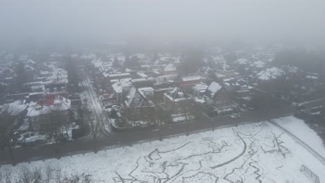 Drone-pulling-back-from-beautiful-suburban-neighborhood-covered-in-snow-and-mist