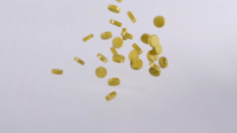 Zeitlupenaufnahme-Von-Gelben-Curcumin-Medikamenten,-Die-In-Der-Luft-Fliegen,-Phenolische-Verbindung