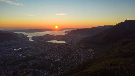 Aerial-shot-over-mountain-with-a-beautiful-view-over-the-city-of-Bergen-while-the-sun-is-going-down