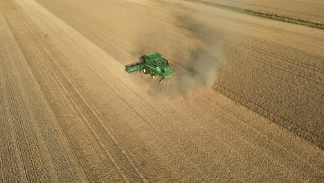 Einrichtung-Einer-Drohnenaufnahme,-Die-Sich-An-Einem-Sonnigen-Tag-In-Großbritannien-Um-Den-Grünen-John-Deere-Mähdrescher-Mit-Staub-Dreht