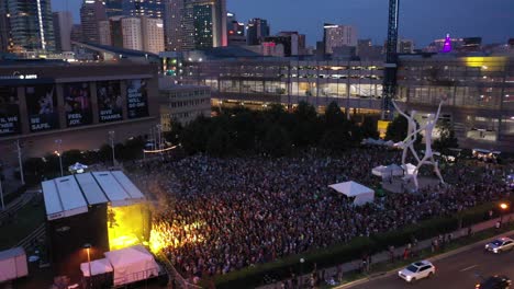 Aerial-over-Speer-Boulevard-of-night-concert-at-Sculpture-Park,-downtown-Denver