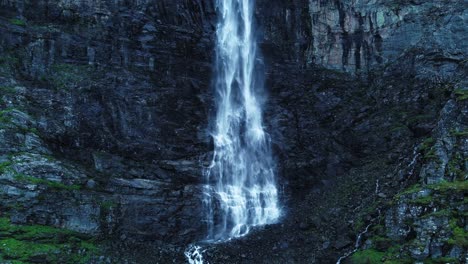 Aerial-backwards-shot-natural-waterfall-falling-at-rocky-mountains