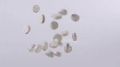 Slow-Motion-Shot-Of-Grey-Supplements-Medical-Pills-Flying-In-Air
