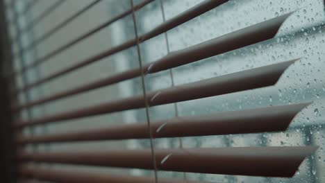 Standbild-Eines-Melancholischen-Blicks-Auf-Einen-Regnerischen-Tag-Aus-Einem-Fenster-Mit-Jalousien,-Hintergrund-Von-Regen,-Der-Auf-Das-Fenster-Fällt