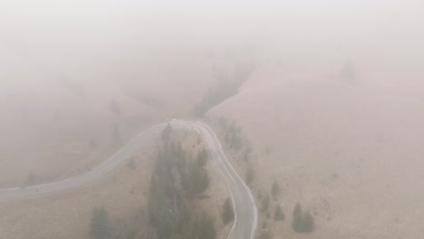 Flying-Through-Foggy-Weather-Over-Rural-Road-In-Bucegi-Mountains-Landscape,-Romania