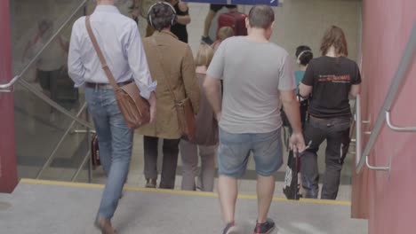 Handheld-shot-of-people-walking-down-stairs-to-a-subway-on-a-summer-day-in-Stuttgart,-Germany,-in-a-documentary-style-with-everything-in-focus