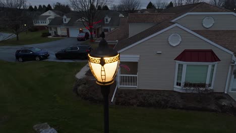 Slow-aerial-orbit-around-lamp-light-with-American-flag-waving-on-retirement-home-in-America