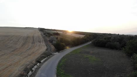 Drone-Flying-On-Plains-With-Isolated-Road-During-Sunset
