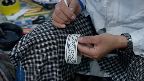 Woman-painting-on-piece-of-pottery-in-Mez,-Morocco