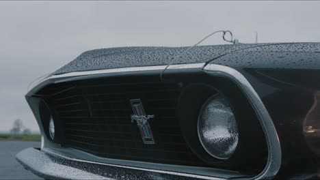 Ford-Mustang-Mach-1-Oldtimer,-Close-Up-View-of-Front-and-Headlight-on-Rainy-Day