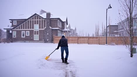 Hombre-Limpiando-La-Nieve-De-La-Entrada-En-Invierno-Después-De-Una-Tormenta-De-Nieve