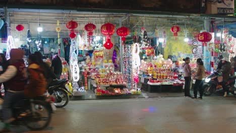 Static-shot-of-a-street-market-in-Lang-Son-with-people-driving-past-the-shop