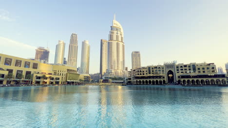 Weite-Ansicht-Des-Dubai-brunnenbereichs-Mit-Dem-Sonnenunterganglicht,-Das-Die-Wolkenkratzer-Und-Hotels-Trifft