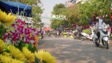 Toma-Estática-Baja-De-Personas-Que-Pasan-Por-Las-Vibrantes-Flores-A-La-Venta-En-Los-Mercados-De-Lang-Son