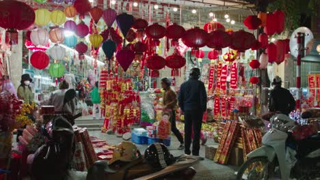 Toma-Estática-De-Clientes-Mirando-Alrededor-De-Un-Puesto-De-Mercado-Por-La-Noche-En-Lang-Son