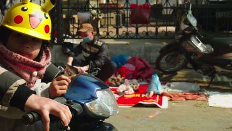 Static-shot-of-a-small-child-sitting-on-the-front-of-a-motorbike-in-the-streets-of-Lang-Son