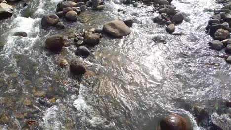 drone-shot,-slow-motion-river-with-rocks