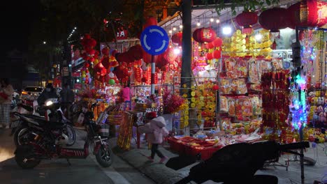 Toma-Estática-De-Clientes-Mirando-Alrededor-De-Los-Mercados-Callejeros-Con-Luces-Brillantes-Parpadeando