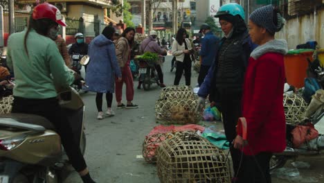 Toma-Estática-De-Mujeres-Saludando-A-La-Cámara-Con-Vendedores-Ambulantes-Tratando-De-Vender-Pollos-Vivos