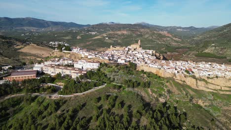 Iznajar-white-mountain-village-and-castle-in-Andalusia,-Spain---Aerial-4k-Dolly-Forward