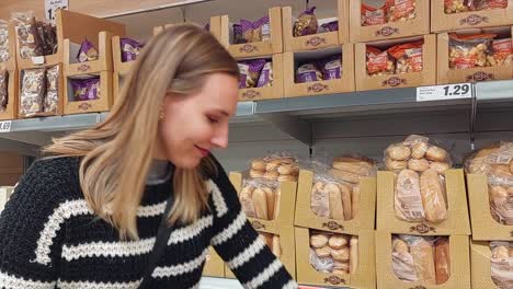 Joven-Rubia-Recogiendo-Y-Seleccionando-Una-Bolsa-De-Pan-De-Un-Supermercado