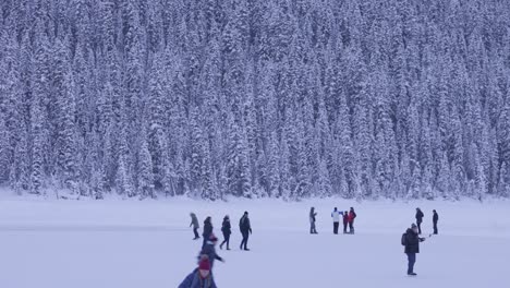 Ice-Skaters-on-Lake-Louise,-Winter-Wonderland,-Banff,-4K