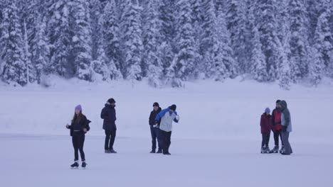 Familias-En-El-Patinaje-Sobre-Hielo-Del-Lago-Louise,-Deportes-De-Invierno,-Banff,-4k