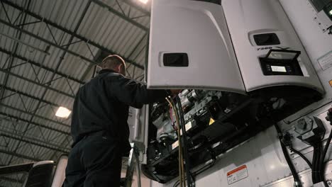 professional-mechanic-opening-doors-of-a-refeer-trailer-and-inspecting-in-a-truck-and-trailer-repairing-shop