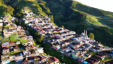 Drone-shot-showing-Asian-village-with-colorful-buildings-on-mountain-during-sunny-day---Nepal-van-Java