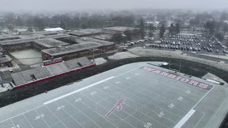 High-aerial-orbit-of-snowstorm-over-American-high-school