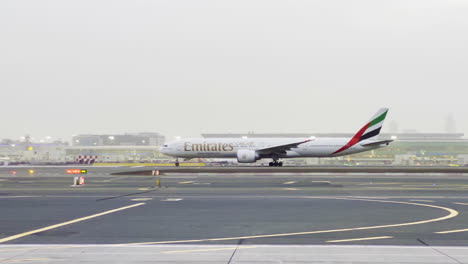 Emirates-Airline-Flugzeug-Bereitet-Sich-An-Einem-Nebligen-Tag-Auf-Den-Start-Am-Flughafen-Dubai-Vor,-Während-Das-Safety-Car-Vorbeifährt