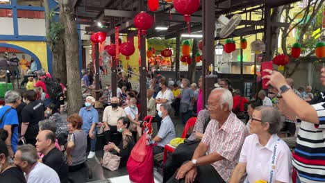 Group-of-senior-locals-and-tourists-anticipate-the-annual-Chinese-New-Year-light-up-event-in-Chinatown,-Singapore