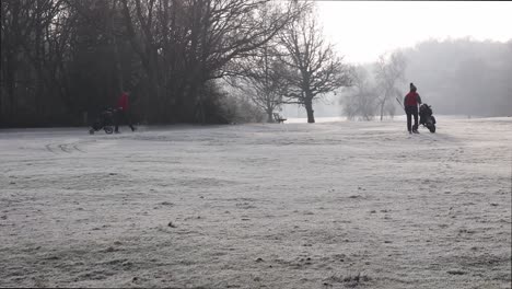 London,-England---January-22-2023:-Golfers-walking-along-a-frost-covered-golf-course-in-the-middle-winter