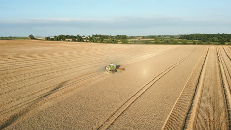 Establishing-Drone-Shot-of-Back-of-Claas-Combine-Harvester-Harvesting-at-Golden-Hour-UK