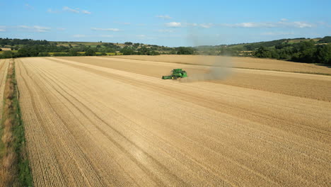 Establishing-Drone-Shot-of-Green-John-Deere-Combine-Harvester-on-Sunny-Summer-Day-UK